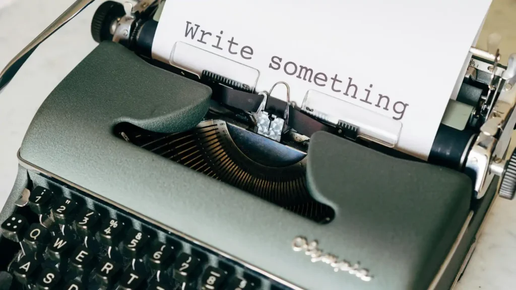 A type writer with a text 'write something' typed on a white page
